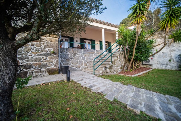 Casa 1B: Garden in front of the stone façade