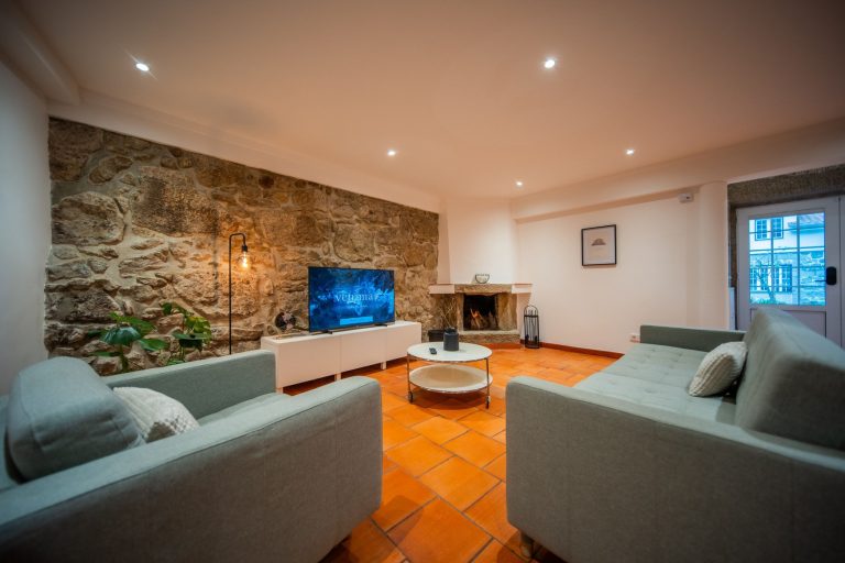 Casa 2: Living room with sofas, stone wall and fireplace