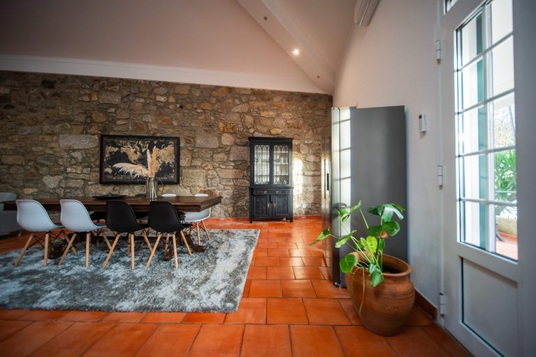 Casa 1B: dining table in front of the stone wall