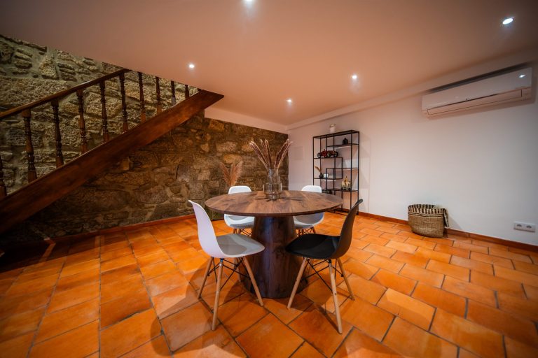 Casa 2: round dining table below the wooden staircase