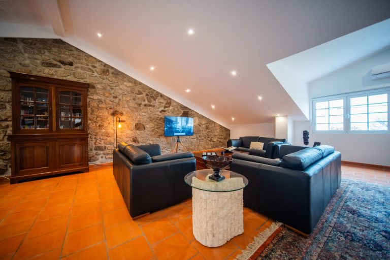 Casa 8: lounge with leather sofas and stone wall