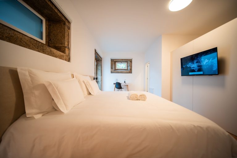 Casa 8: double bed below a window in the stone wall