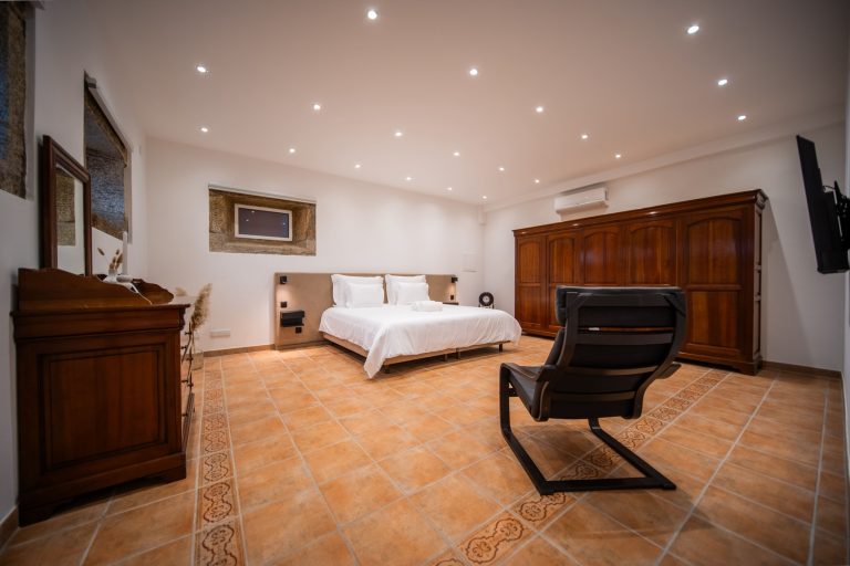 Casa 8: large bedroom with armchair and old wooden furniture