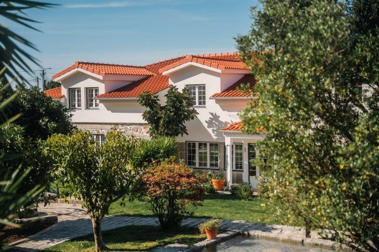 House with red roof behind the garden